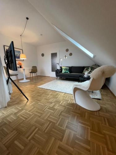 een woonkamer met een bank en een stoel bij Sonnige Dachwohnung nahe dem Klinikum. in Oldenburg