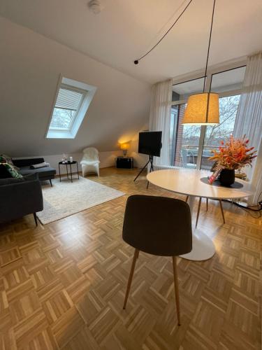 een woonkamer met een tafel en een bank bij Sonnige Dachwohnung nahe dem Klinikum. in Oldenburg