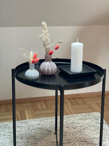 a black table with vases and a candle on it at Sonnige Dachwohnung nahe dem Klinikum. in Oldenburg