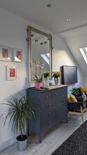 a living room with a dresser and a mirror at Sidney Grove B&B in Newcastle upon Tyne