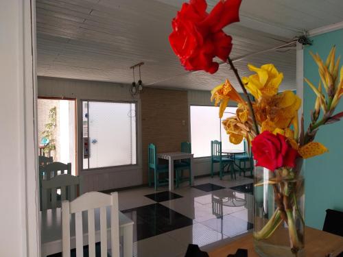 a vase with flowers on a table in a room at Hostal Avenue in La Serena