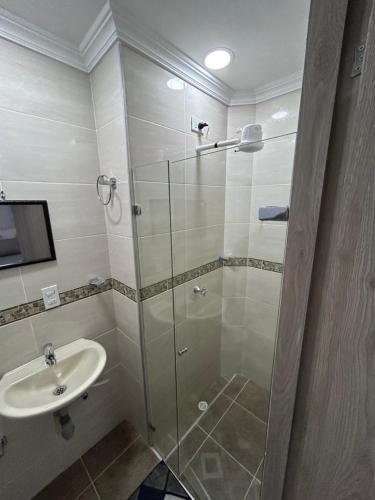 a bathroom with a glass shower and a sink at Joyful! Medellin Itagüi in Itagüí