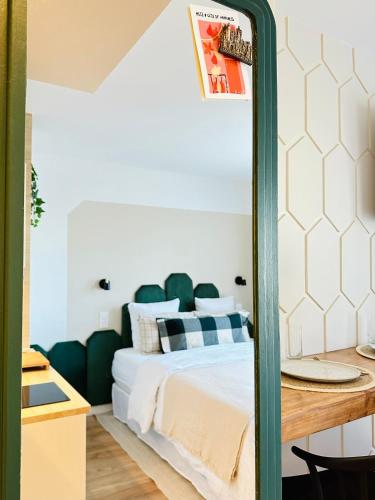 een slaapkamer met een bed met een groene spiegel bij L’émeraude - Superbe studio tout équipé + parking in Metz