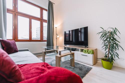 a living room with a couch and a tv and a table at Modern living in city centre in Košice