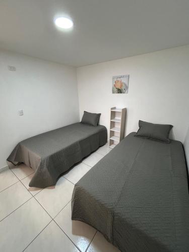 Un dormitorio con 2 camas y una escalera. en Joyful! Medellin Itagüi en Itagüí