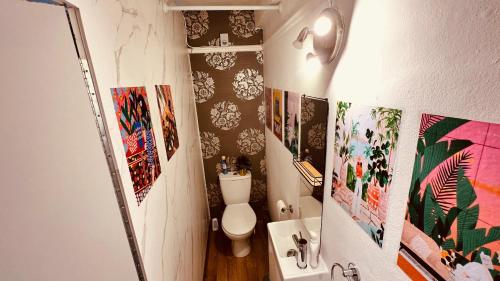 uma casa de banho com WC e fotografias na parede em Rest Boutique Notting Hill em Londres