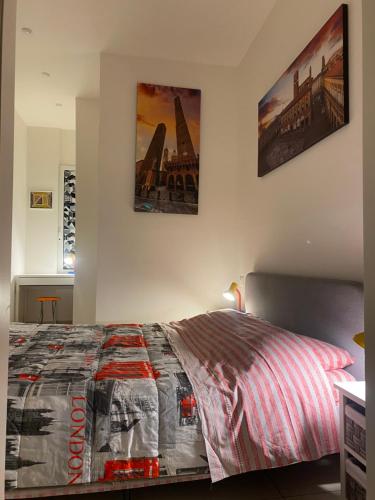 sypialnia z łóżkiem z dwoma obrazami na ścianie w obiekcie Residence Dall’Ara w Bolonii