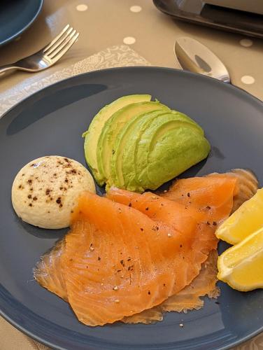 a blue plate of food with fish and avocado at Sidney Grove B&B in Newcastle upon Tyne