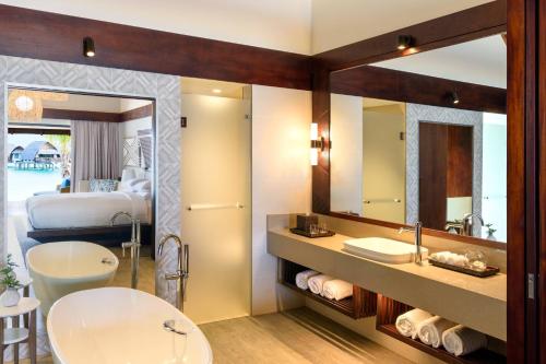 a bathroom with a sink and a bed and a mirror at Fiji Marriott Resort Momi Bay in Momi