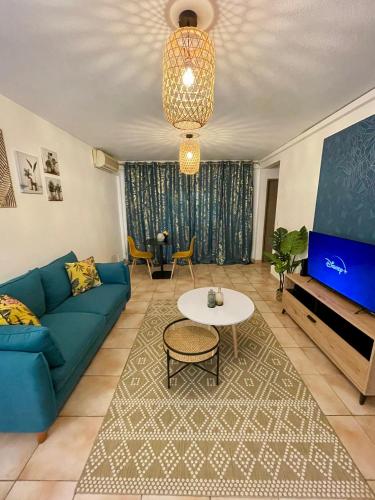 een woonkamer met een blauwe bank en een tafel bij Le Toucan Tropical, F2 bis emplacement central in Fort-de-France