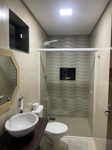uma casa de banho com um chuveiro, um WC e um lavatório. em POUSADA DA MAGA em Chapada dos Guimarães