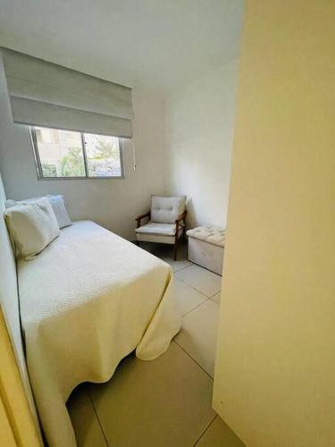 a bedroom with a bed and a chair and a window at Apto VIP em frente à ARENA MRV / Expominas in Belo Horizonte