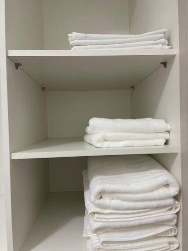 a white closet with white towels on a shelf at Apto VIP em frente à ARENA MRV / Expominas in Belo Horizonte