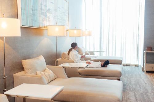 a woman sitting on a couch in a hotel room at Marriott Marquis Houston in Houston