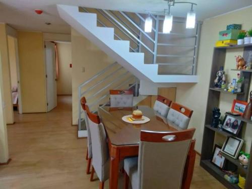 uma sala de jantar com uma mesa e cadeiras e uma escadaria em Tait's House - Cómodo departamento Dúplex - Ate em Lima