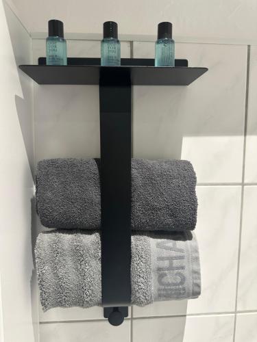 a black towel rack with three towels on it in a bathroom at Butler Suites in Düsseldorf