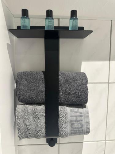 un toallero negro con 3 toallas en el baño en Butler Suites, en Düsseldorf