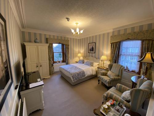 a bedroom with a bed and a couch and a chair at West Acre House in Alnwick