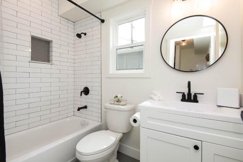 a white bathroom with a sink toilet and a mirror at Beautiful Apartment in Atwater Village in Glendale