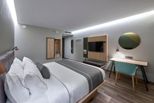 Habitación de hotel con cama grande y escritorio. en City Express Plus by Marriott Tijuana en Tijuana