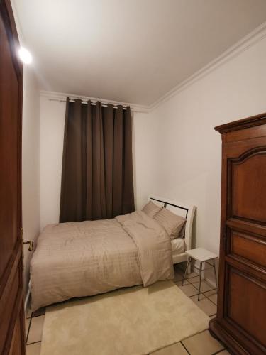 - une petite chambre avec un lit et une commode dans l'établissement L'Cosy Suite - Charming 2BR in Bagnolet, à Bagnolet