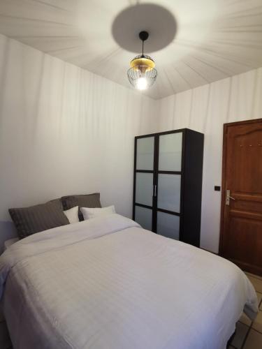 a bedroom with a large white bed and a ceiling at L'Cosy Suite - Charming 2BR in Bagnolet in Bagnolet