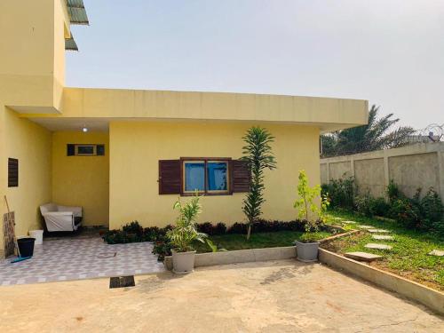 ein Haus mit einer Terrasse mit Pflanzen davor in der Unterkunft Cotonou dwelling AAC 1 in Porto-Novo