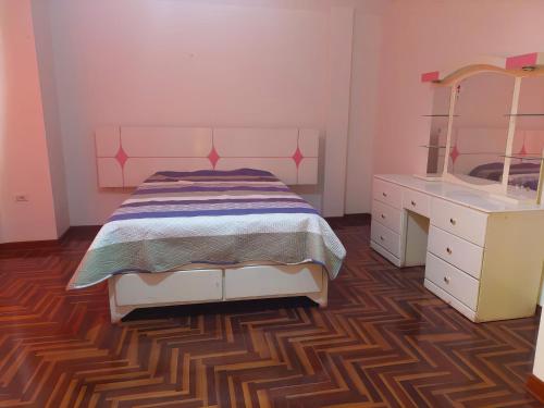 a bedroom with a bed and a vanity and a sink at Casa familiar Cajamarca-Amoblado in Los Baños del Inca