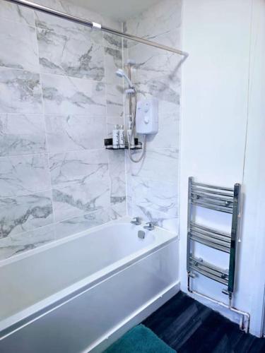 een witte badkamer met een bad en een douche bij SwankyHome4Groups/Contractors/M6 in Birmingham