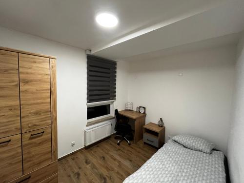 a bedroom with a bed and a desk and a window at Separate Room in a New Townhouse in Warsaw in Warsaw
