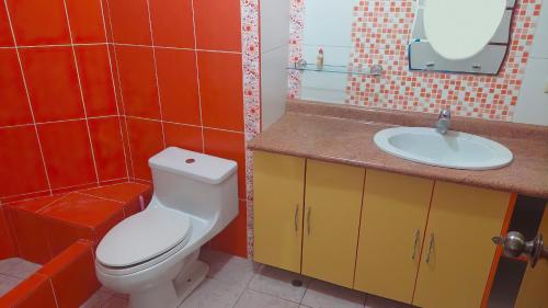 a bathroom with a white toilet and a sink at Casa familiar Cajamarca-Amoblado in Los Baños del Inca