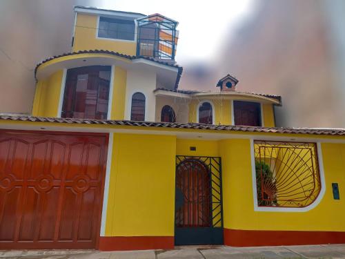 Casa blanca y amarilla con puertas rojas en Casa familiar Cajamarca-Amoblado, en Los Baños del Inca