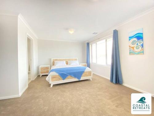 a white bedroom with a bed and a window at Scotty’s Place – Luxury Retreat in Inverloch
