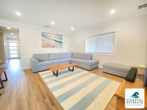 a living room with a couch and a coffee table at Scotty’s Place – Luxury Retreat in Inverloch