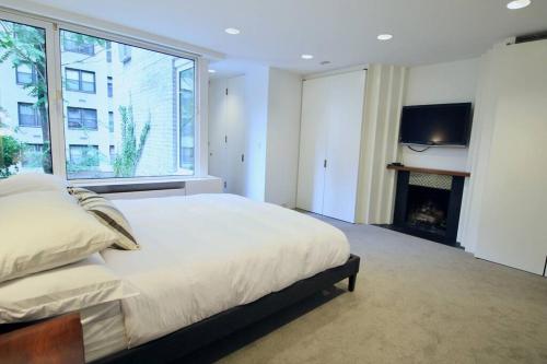 um quarto com uma cama grande e uma lareira em Private Beautiful Eastside Townhome near UN em Nova York