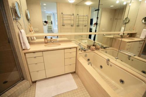 uma casa de banho com uma banheira e um lavatório e uma banheira em Private Beautiful Eastside Townhome near UN em Nova York