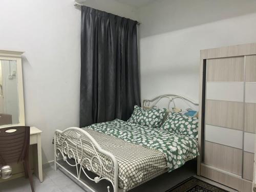 Nilai Bronizam Homestay في نيلاي: غرفة نوم بسرير وستارة سوداء