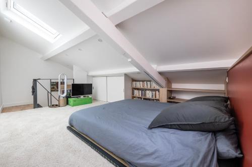 une chambre avec un grand lit dans un grenier dans l'établissement Appartement cosy pour deux aux portes de Paris, à Montreuil