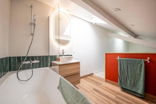 une salle de bain avec une baignoire, un lavabo et un miroir dans l'établissement Appartement cosy pour deux aux portes de Paris, à Montreuil