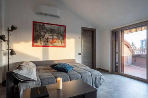 a bedroom with a bed and a table and a window at [Aeroporto Orio Al Serio • 10 Minuti] Attico Lusso in Seriate
