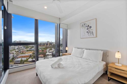 1 dormitorio con cama blanca y ventana grande en Homely 1-Bedroom with Parking and Wifi, en Brisbane
