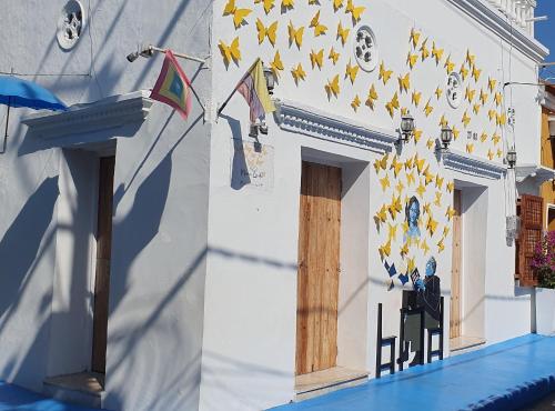 Un bâtiment blanc avec une table et quelques drapeaux dans l'établissement Casa Evelyn, à Carthagène des Indes