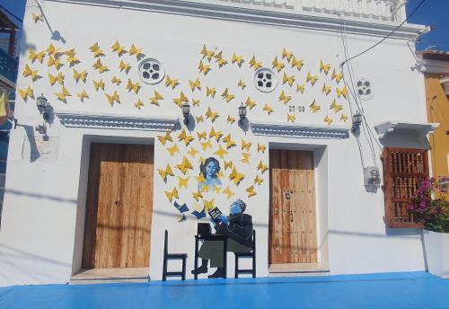 a man sitting in a chair in front of a building with stars at Casa Evelyn in Cartagena de Indias