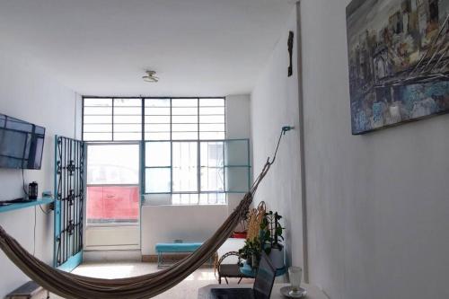 eine Hängematte im Wohnzimmer mit einem großen Fenster in der Unterkunft Casa Esperanza in Zarumilla