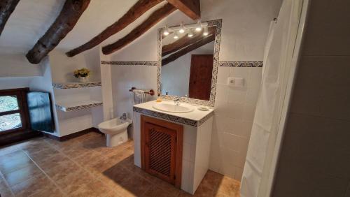 y baño con lavabo, espejo y aseo. en Casa rural Casa Montoya, en Barranda
