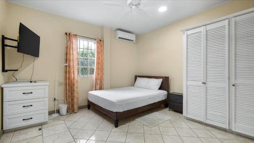 a bedroom with a bed and a television in it at Cosy 1 Bd-Rm is steps away from Beach access. in Morne Rouge