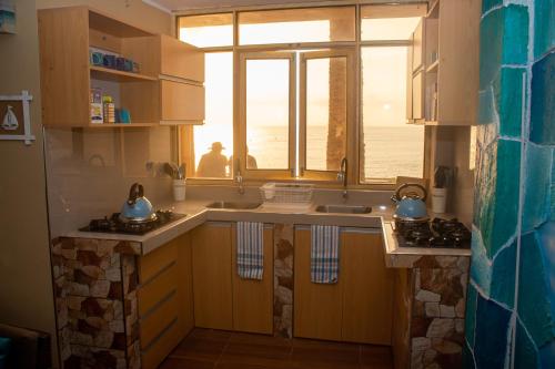 une cuisine avec un évier et une fenêtre dans l'établissement Hotel Sunset Chancay, à Chancay