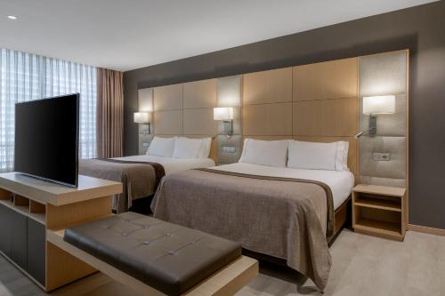 バルセロナにあるAC ホテル ビクトリア スイーツ ア マリオット ライフスタイル ホテルのベッド2台、薄型テレビが備わるホテルルームです。