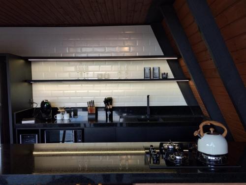 a kitchen with a black counter top with a tea kettle at Ávora Cabana in Cambara do Sul