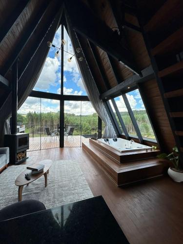 a large room with a bed and a large window at Ávora Cabana in Cambara do Sul